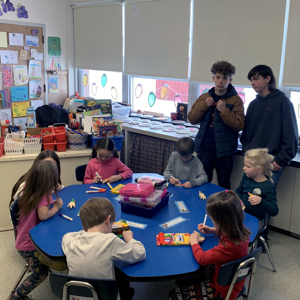 Kindergarten students decorate ornaments with assistance from eighth graders