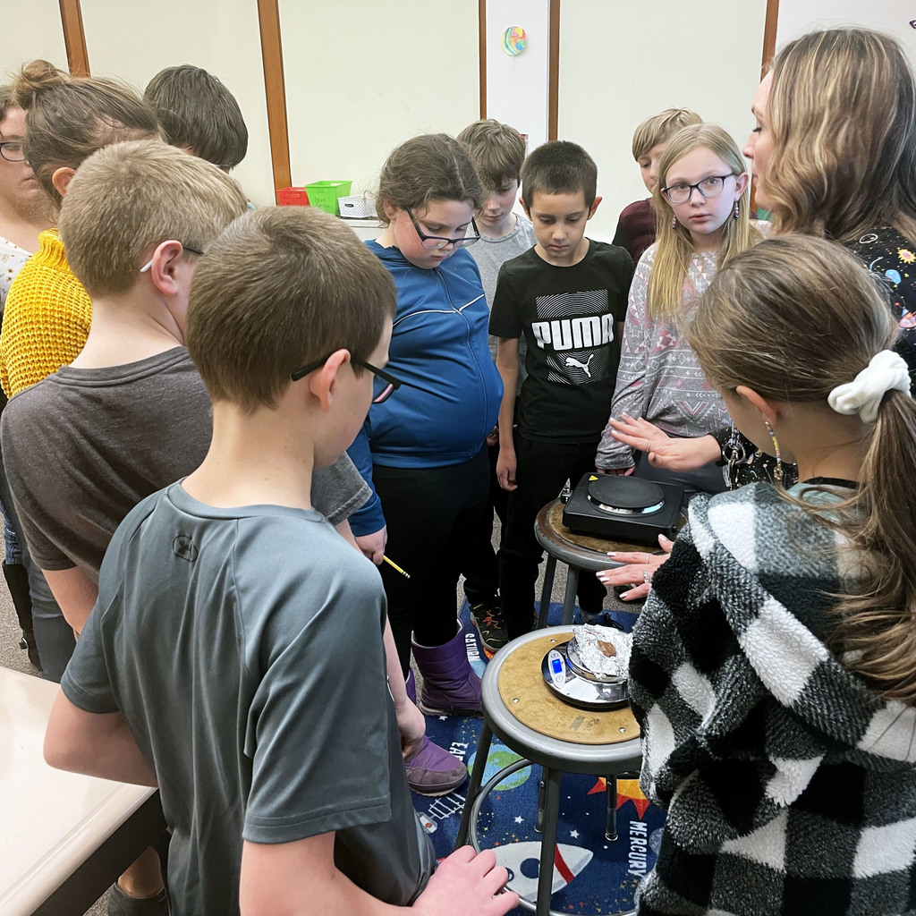 Students watch as the teacher demonstrates a lab experiment