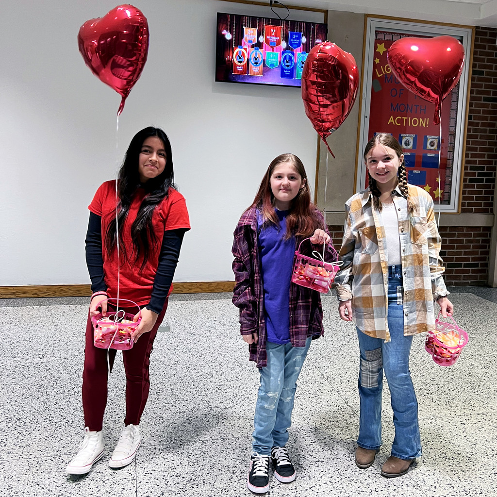 Students hold baskets with heart balloons tied to them