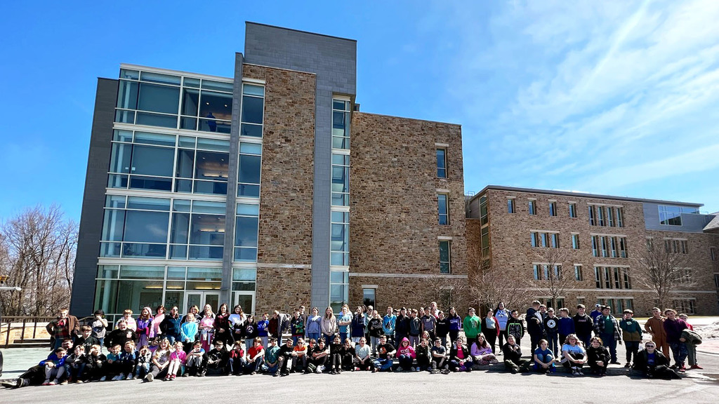 Students pose for a group photo outside a Hamilton College building