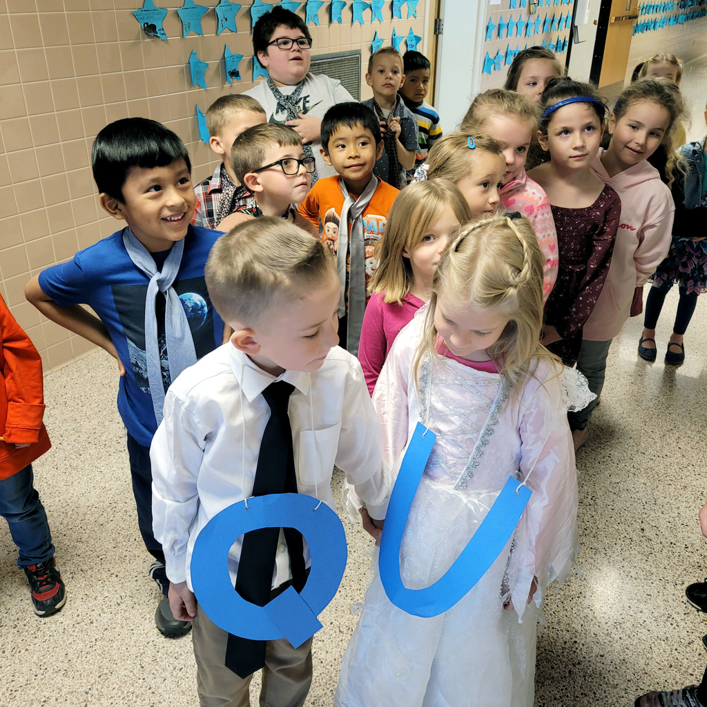 Students line up in a procession to celebrate the "marriage" of "Q" and "U"