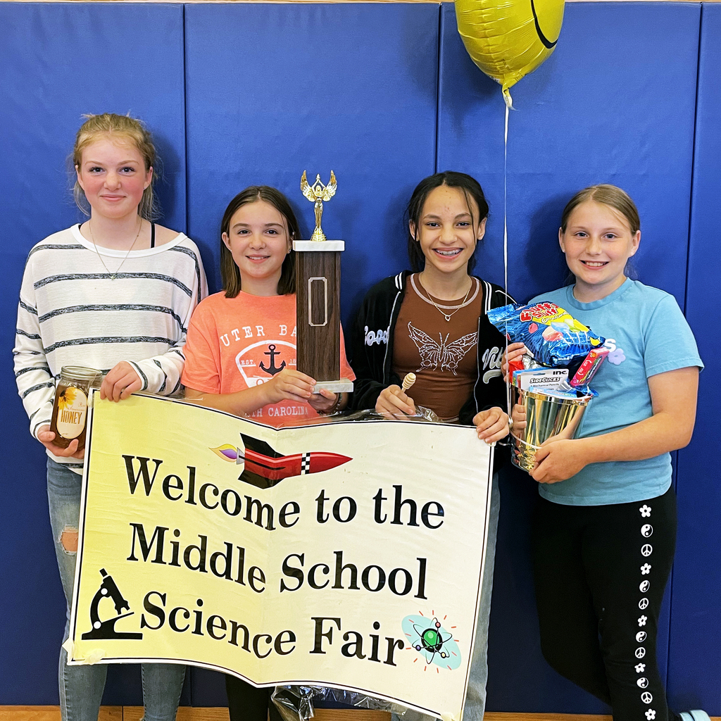 Students pose with awards and a banner reading "Welcome to the Middle School Science Fair"