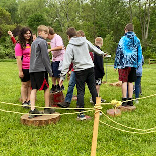 Students navigate a low ropes course
