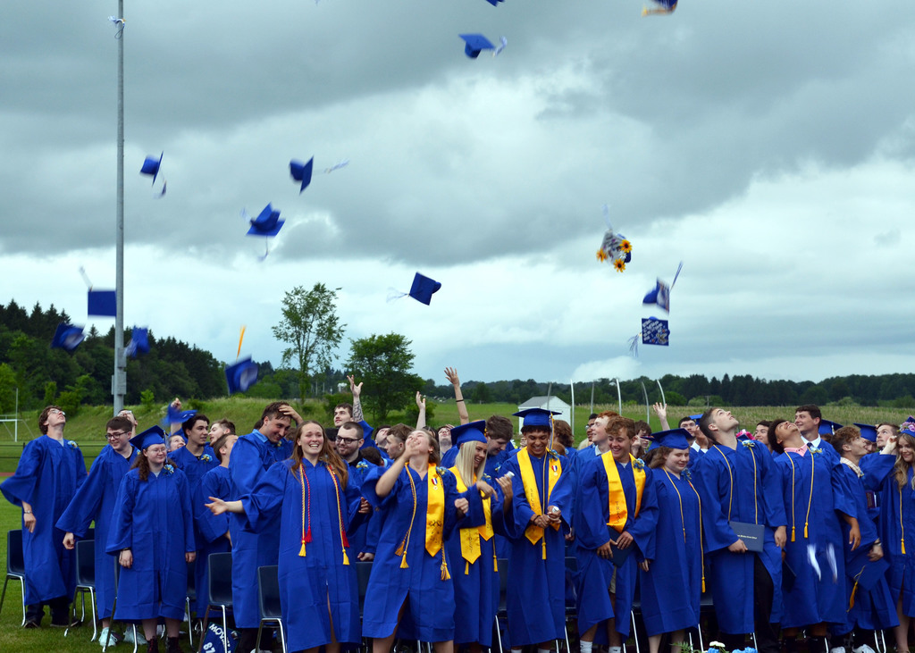 Students toss caps into the air after the ceremony