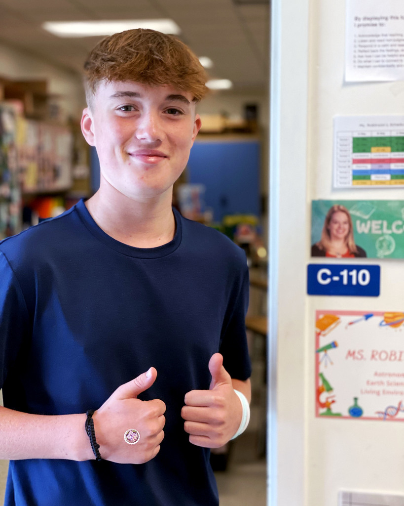 student stands outside Ms. Robinson's classroom