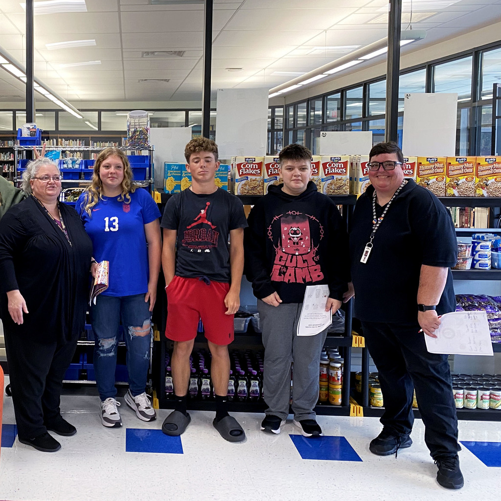 Students and staff stand in front of the pantry in the hub