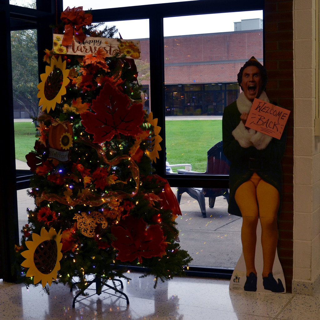 Fall-themed spirit tree with a cardboard cut out of Buddy the Elf